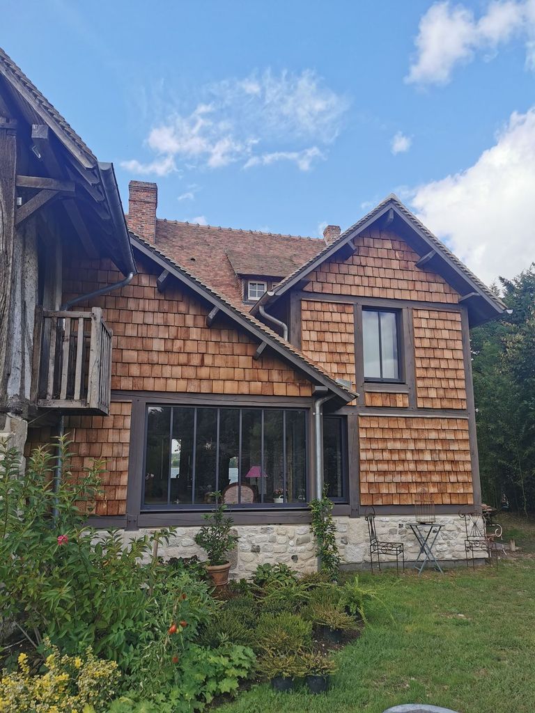 Extension bardée de bardeaux de bois greffée sur une longère à colombages