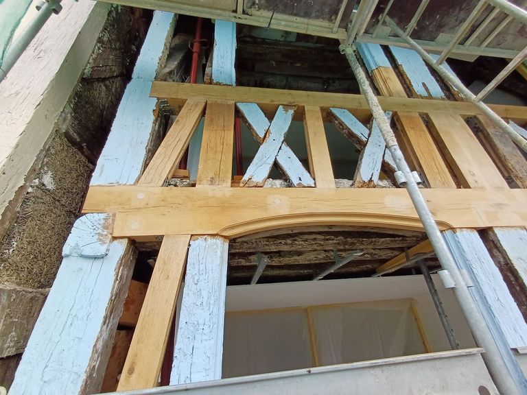 Vue large d’un pan de bois en cours de reprise, bois neufs et bois anciens