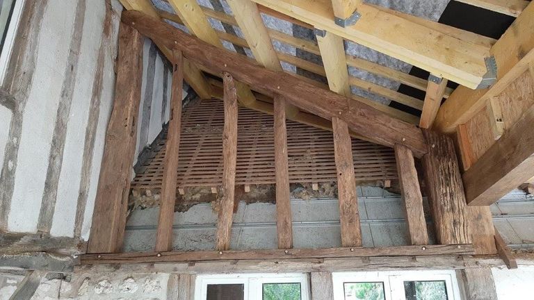 Pan de bois ancien conservé sous une charpente neuve