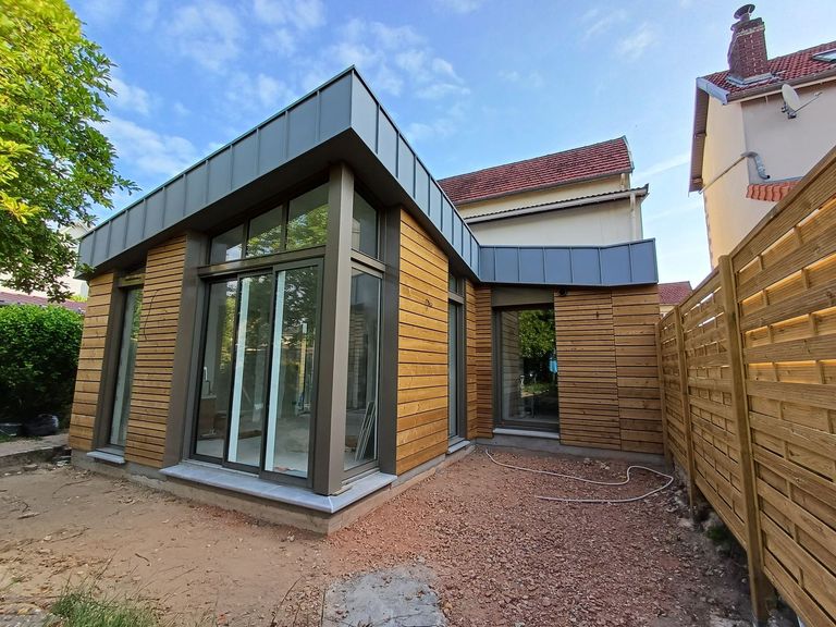 Extension contemporaine associant bardage bois et couverture en zinc