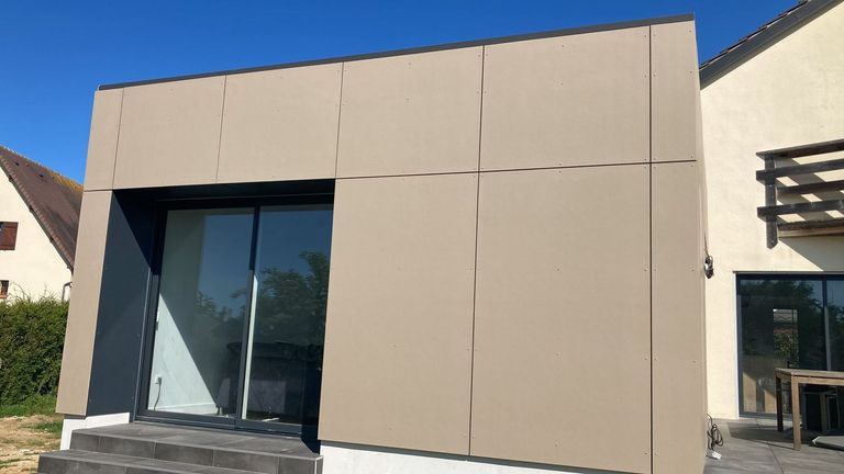 Extension en ossature bois habillée de panneaux de façade, grande baie d’angle