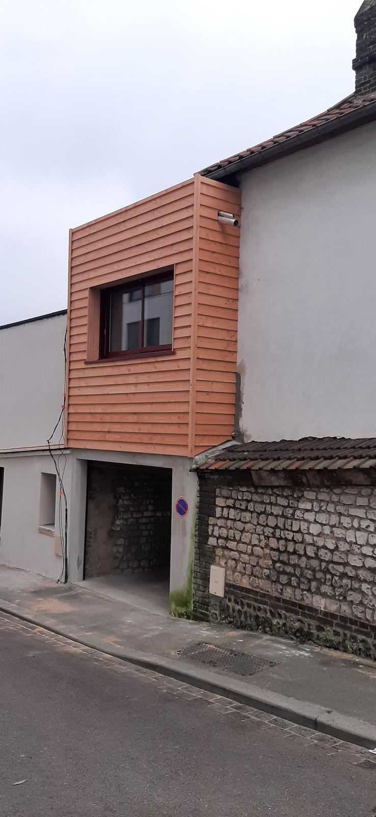 Volume bardé de bois glissé entre deux murs de brique, en cœur d’îlot