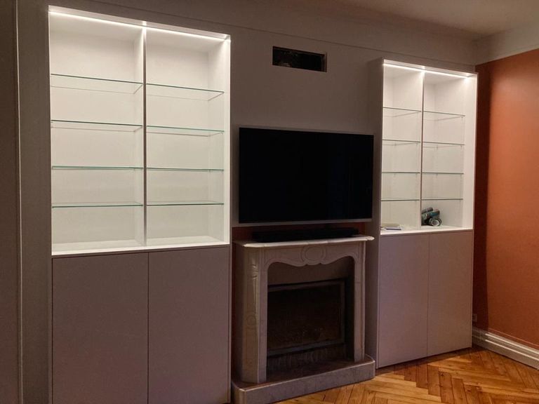 Ensemble menuisé sur mesure autour d’une cheminée, vitrines éclairées de part et d’autre
