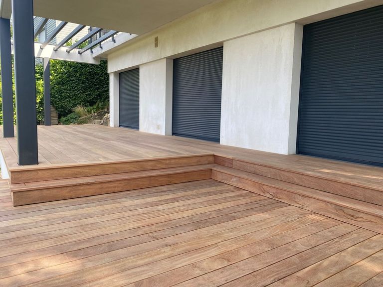 Terrasse en bois bordée d’une banquette et d’un emmarchement