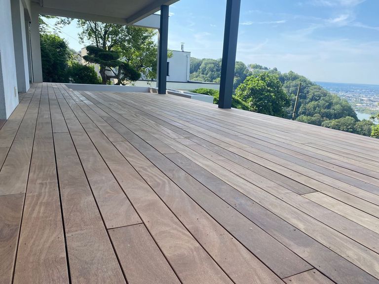 Terrasse en bois abritée par un auvent, garde-corps métallique