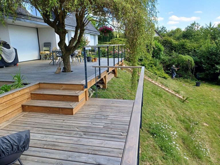 Escalier et rampe d’accès en bois desservant une terrasse en pente