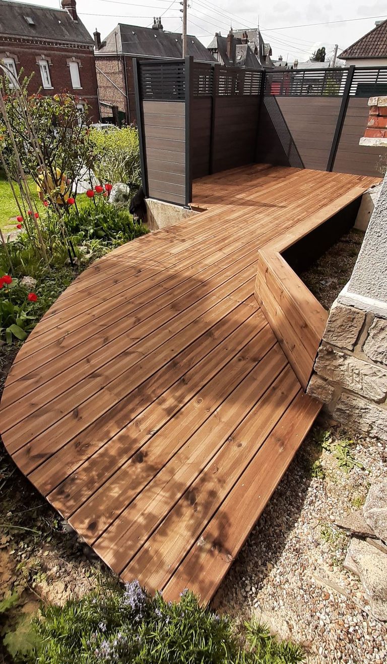 Terrasse en bois dont les lames suivent une bordure courbe