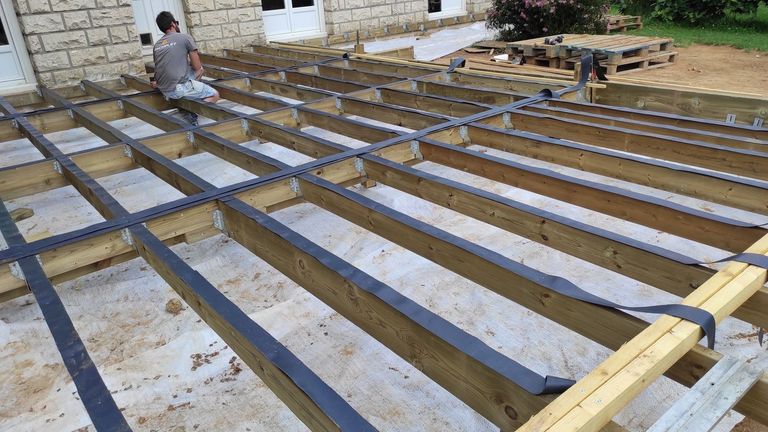Structure d’une terrasse en bois : lambourdes posées sur plots avant le platelage